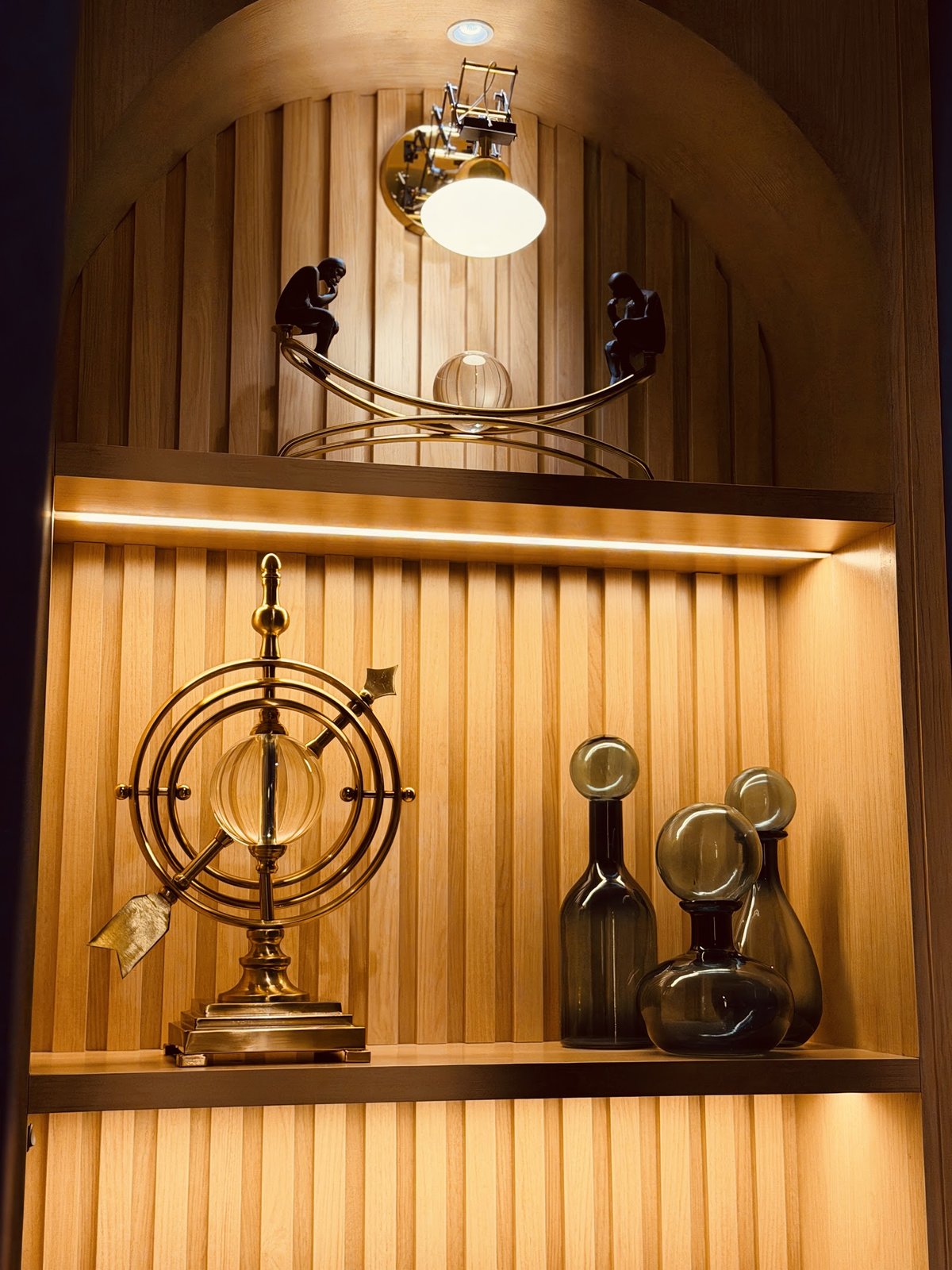 Nicho de madeira com iluminação e objetos decorativos da clínica